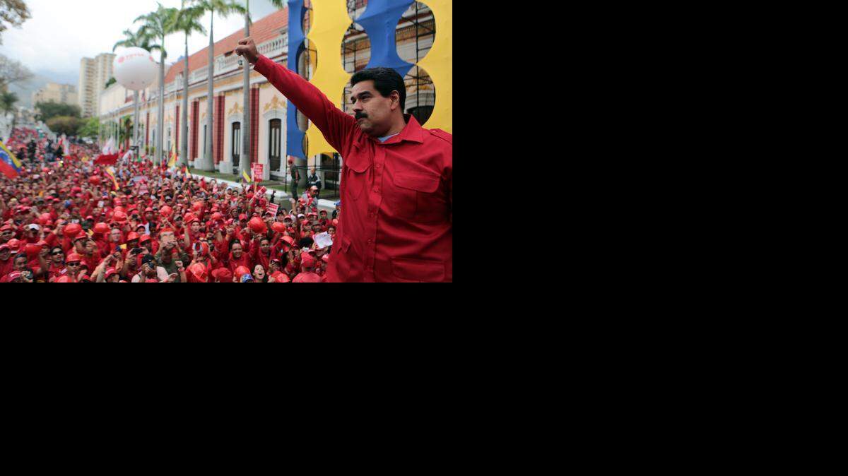 
Con el puño en alto, el presidente Nicolás Maduro saluda a sus partidarios reunidos en una calle de Caracas en febrero de este año.
