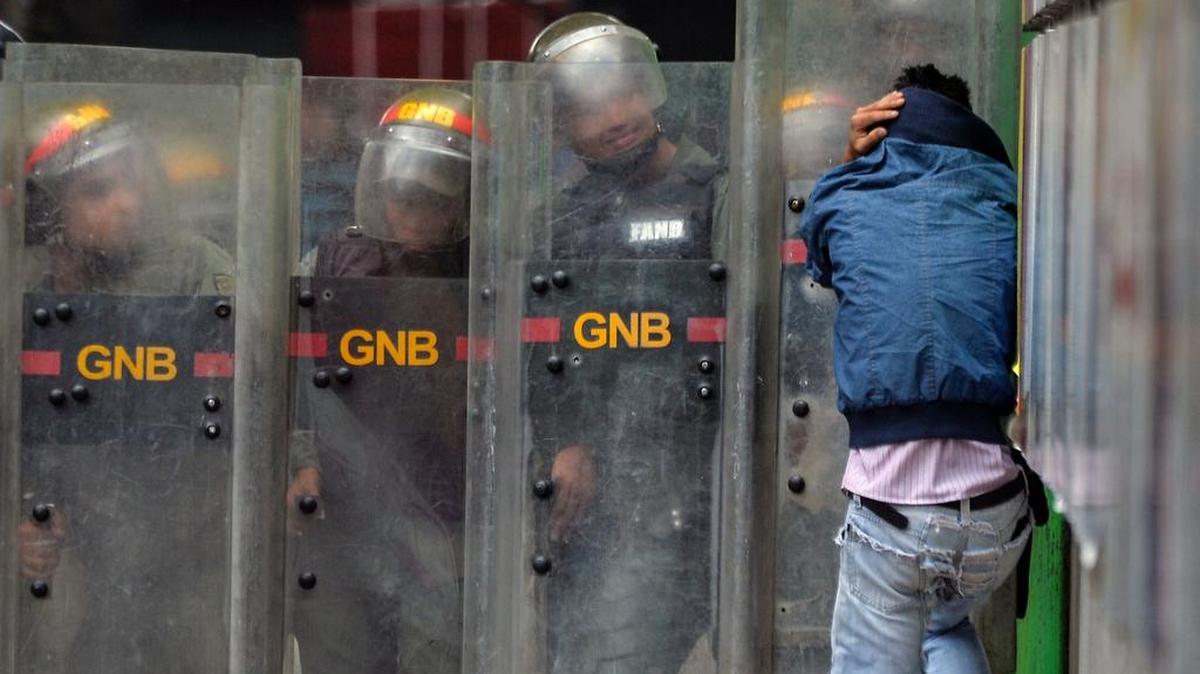 Un hombre se protege durante enfrentamientos entre activistas de la oposición y la policía antidisturbios, en una protesta contra el gobierno del presidente Nicolás Maduro, en Caracas el 3 de junio de 2017.