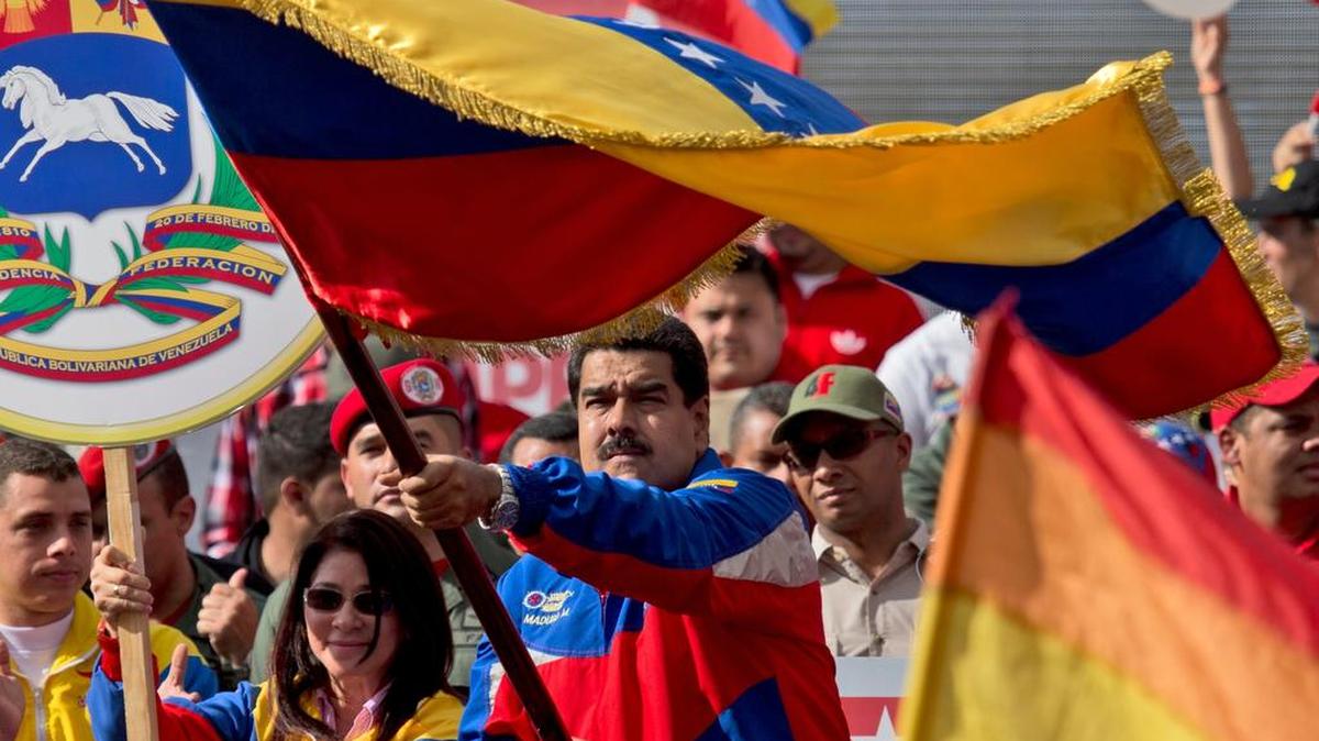 
El presidente de Venezuela, Nicolás Maduro, junto con su esposa Cilia Flores, ondea una bandera en febrero durante una manifestación en Caracas. La primera dama registró el miércoles su candidatura a las parlamentarias de diciembre.
