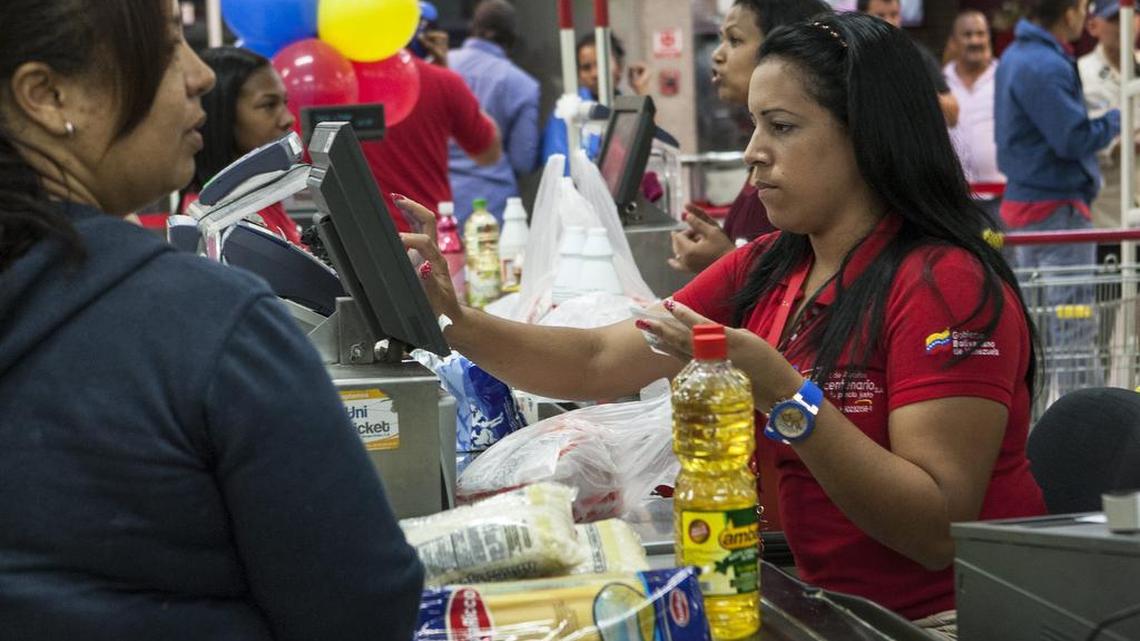 
Una trabajadora de un supermercado público cobra los productos a un cliente el 12 de enero de 2015, en Caracas, Venezuela.
