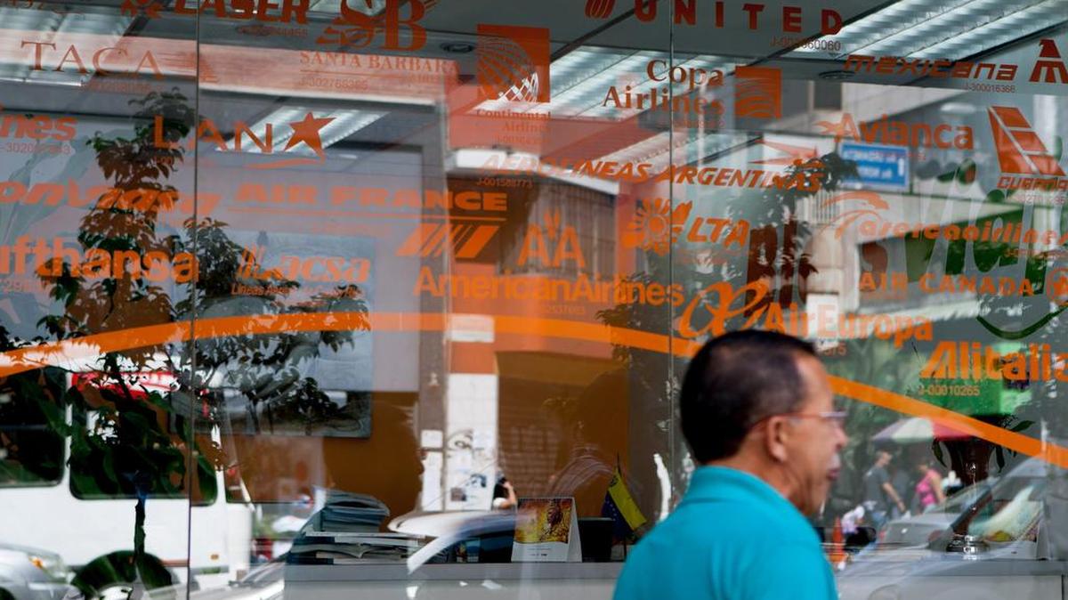 Un hombre camina el 24 de enero de 2014, frente a una agencia de viajes en el centro de Caracas (Venezuela).