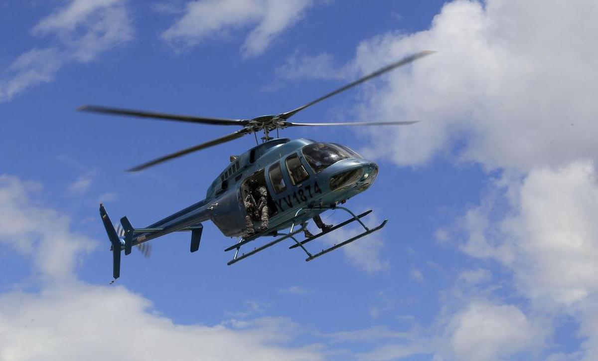 Un helicóptero que transporta a un miembro de la policía secreta vuela sobre la base militar de Paramacay en Valencia, Venezuela, el domingo 6 de agosto de 2017.