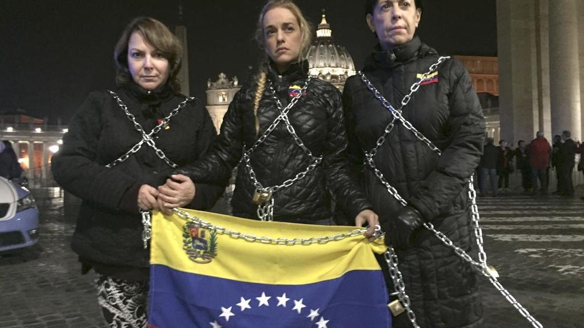 La esposa del preso político venezolano Leopoldo López, Lilian Tintori (c), se encadenó el domingo frente al Vaticano para pedir la liberación de todos los "presos políticos" en la próxima reunión de diálogo entre la oposición y el Gobierno de este martes.