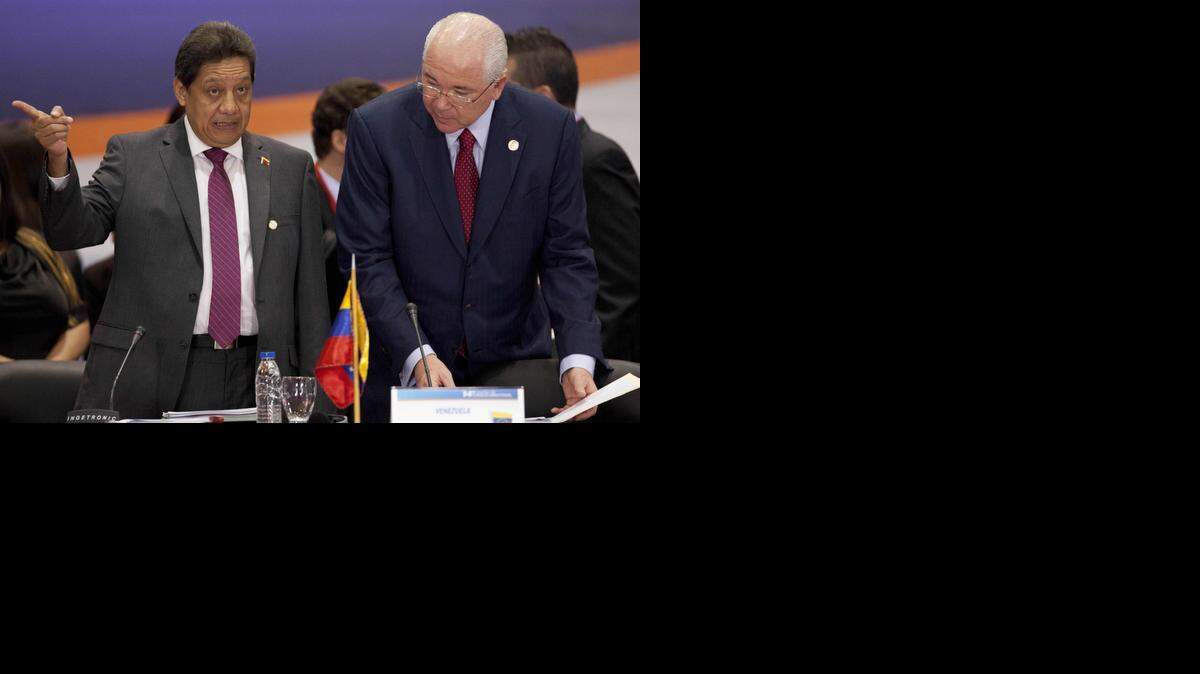 
Asdrubal Chávez (izq.), presidente de Petróleos de Venezuela, y Rafael Ramírez, ministro de Relaciones Exteriores, conversan durante una reunión de Petrocaribe el jueves 20 de noviembre del 2014, en Caracas. 
