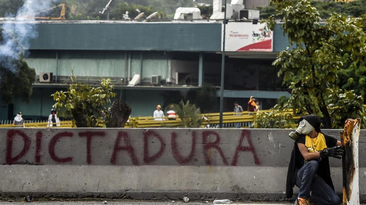 Un manifestante opositor se protege detrás de un escudo durante las protestas contra el gobierno de Nicolás Maduro, el jueves en Caracas.
