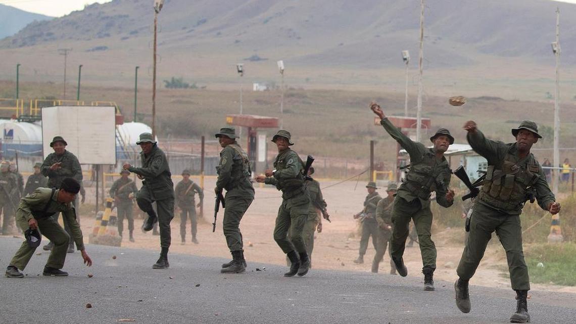 Grupos de personas declaradas antichavistas (fuera de cuadro) se enfrentan con miembros de la Guardia Nacional Bolivariana de Venezuela este sábado en el paso fronterizo ubicado en la localidad de Pacaraima (Brasil), en el límite fronterizo entre Brasil y Venezuela, cerrado desde el jueves por orden del Gobierno de Nicolás Maduro.