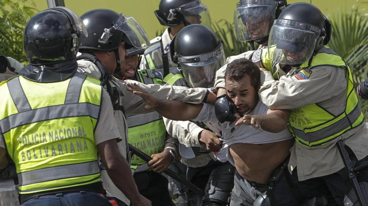 Miembros de la Policía Nacional Bolivariana detienen a un manifestante el jueves 1 de septiembre de 2016, al finalizar la denominada "Toma de Caracas", una marcha convocada hace semanas por la alianza de partidos Mesa de la Unidad Democrática (MUD) para presionar al Poder Electoral por la agenda del referendo, que impulsa la oposición, para revocar al presidente venezolano Nicolás Maduro, en la ciudad de Caracas (Venezuela).