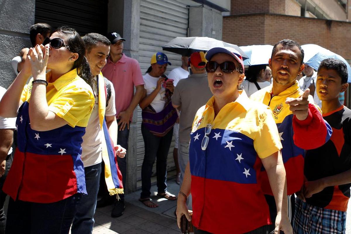 Un grupo de venezolanos asisten a votar para la consulta popular de la oposición contra el proceso constituyente impulsado por el presidente de Venezuela, Nicolás Maduro el domingo 16 de julio de 2017, en Medellín (Colombia).
