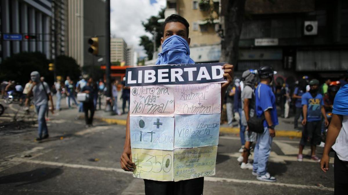 Un manifestante sostiene un cartel durante las protestas en Caracas, Venezuela, el miércoles 14 de junio de 2017.