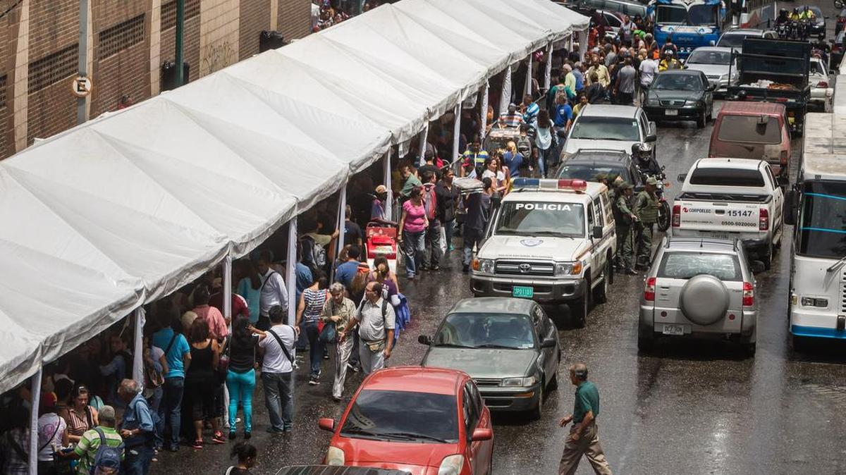 Un grupo de personas hace fila para validar el 1% de las firmas requeridas para solicitar un referendo revocatorio contra el presidente venezolano, Nicolás Maduro, el 23 de junio de 2016, en la ciudad de Caracas (Venezuela).