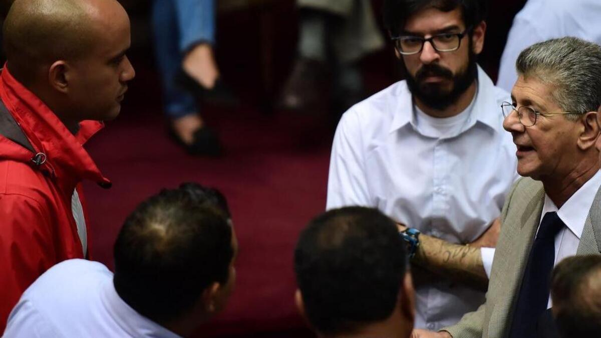El presidente de la Asamblea Nacional, Henry Ramos Allup (der.), habla con el diputado Héctor Rodríguez, jefe de la bancada chavista, durante una sesión parlamentaria el martes en Caracas.