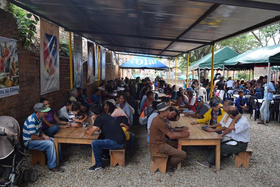 La Iglesia católica colombiana ofrece más de 1,000 comidas gratis al día a venezolanos que huyen de la crisis económica en su país. En esta imagen, un grupo de personas espera para comer.