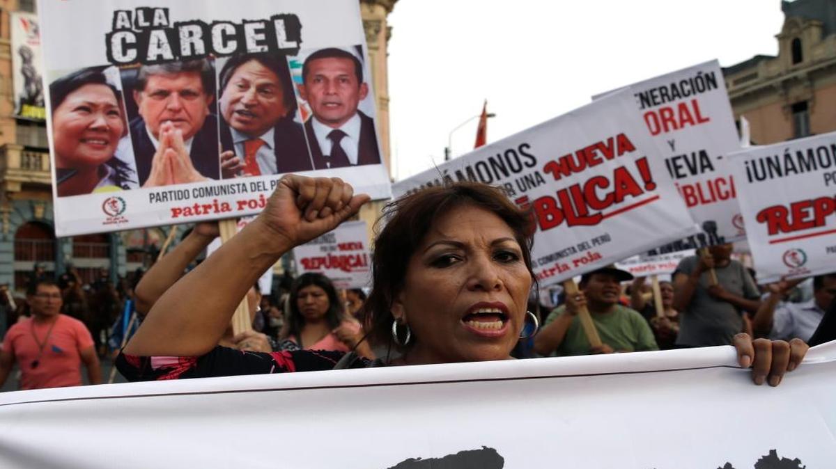 Protestas en contra de la corruptión, con carteles que portan fotos de los ex mantaratios de Perú, de izq. a der., Alan Garcia, Alejandro Toledo, y Ollanta Humalay y la compañia brazileña Odebrecht.