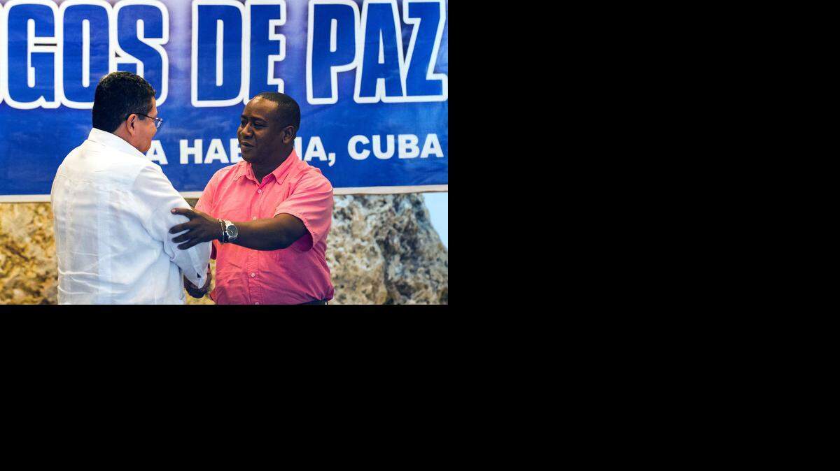 
El comandante de las FARC Pablo Catatumbo (izq.) estrecha la mano a uno de los sobrevivientes de la masacre en la que murieron 79 personas.


