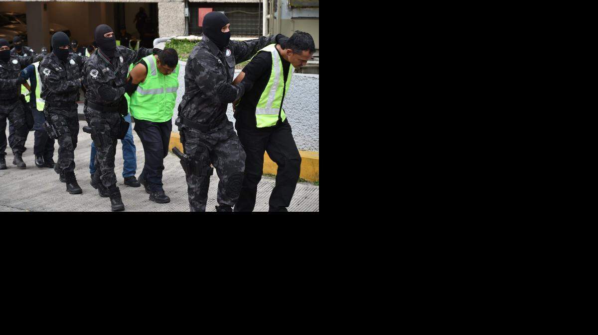
Agentes federales trasladan a policías capturados por la desaparición de 43 estudiantes en Guerrero, México. Los federales arrestaron también al jefe del cartel Guerreros Unidos, por el mismo crimen.
