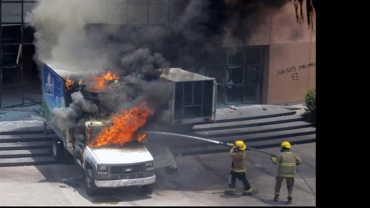 
Bomberos combaten las llamas en un vehículo incendidado frente al Congreso del estado de Guerrero, en México, el domingo, tras una protesta por la desaparición de los 43 estudiantes.
