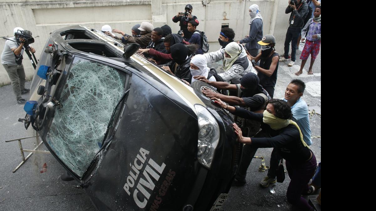 
Manifestantes voltean una patrulla de la policía durante una protesta contra la Copa Mundial de Fútbol, en Belo Horizonte, en el 2014.
