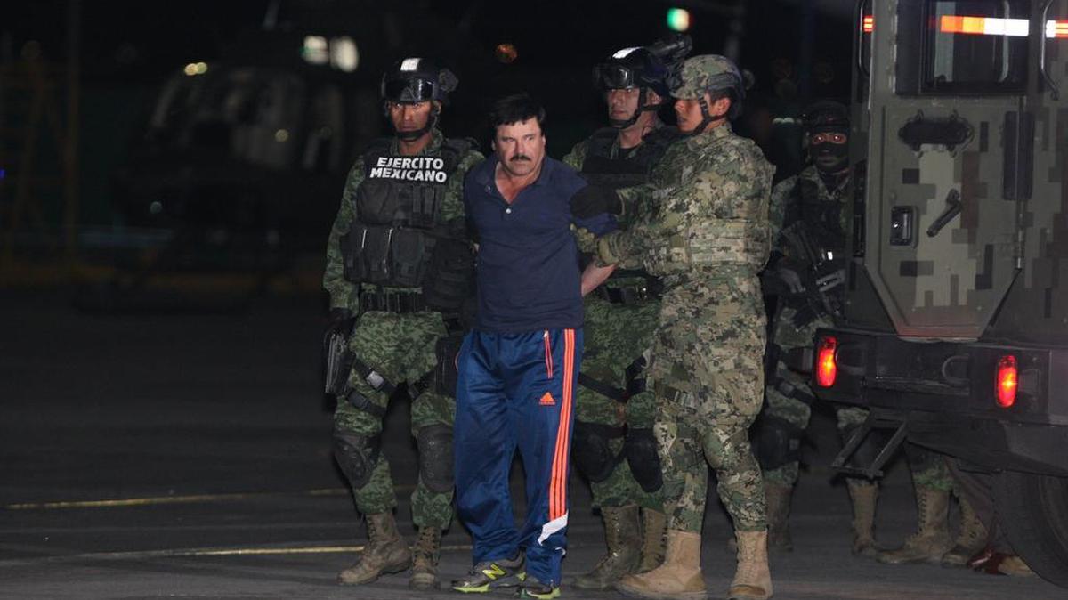 El narcotraficante Joaquín "El Chapo" Guzmán (c) es conducido, el viernes 8 de enero de 2016, a un helicóptero de la Marina Armada de México, en la capital mexicana tras su recaptura en la ciudad de Los Mochis, Sinaloa (México). 