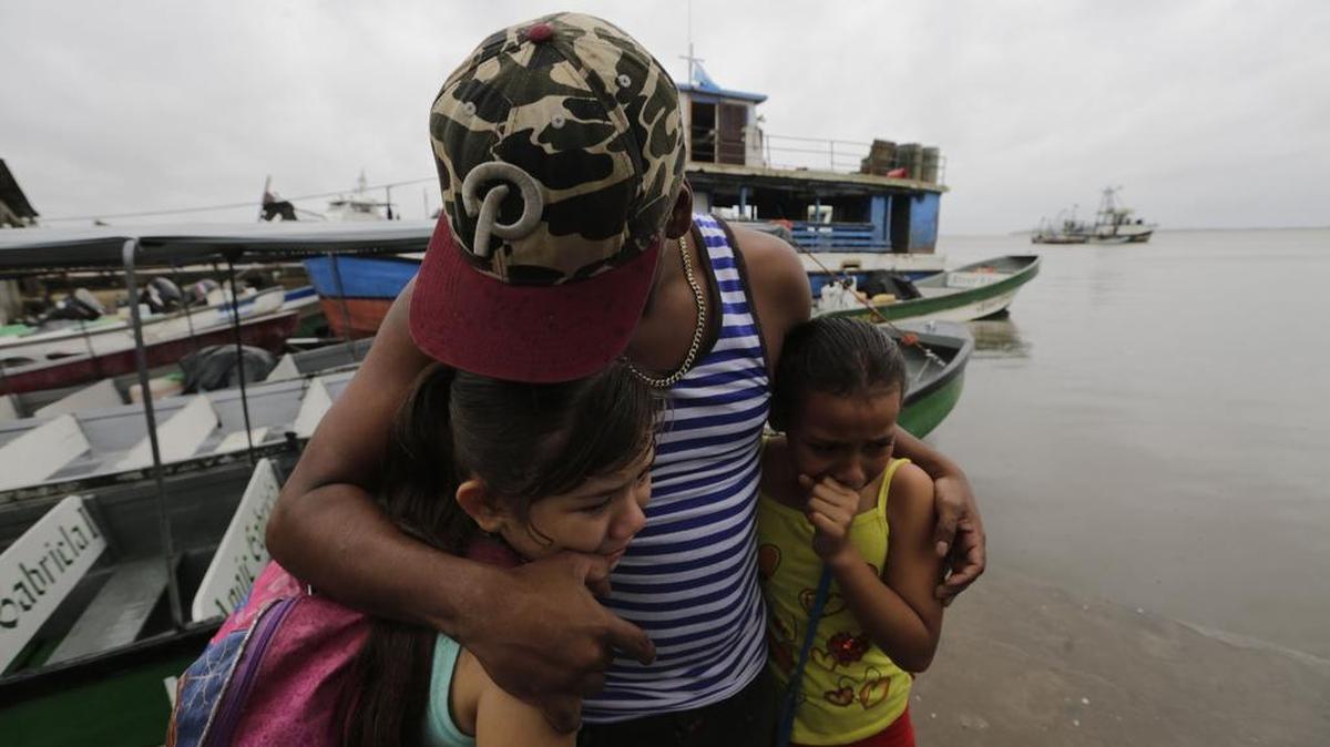Dos niños buscan refugio bajo el abrazo de su padre antes de que el huracán Otto llegue a Bluefields, Nicaragua el 23 de noviembre de 2016.