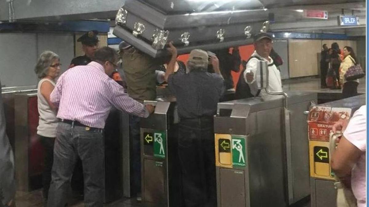 Grupo de personas intenta entrar a una estación del metro de la Ciudad de México con un ataúd.