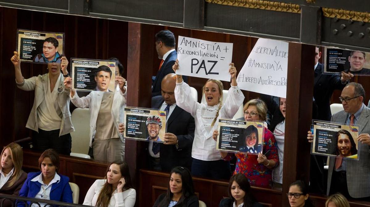 Lilian Tintori (c), esposa del opositor encarcelado Leopoldo López, y familiares de presos políticos muestran el jueves afiches en el palco de invitados del hemiciclo de sesiones de la Asamblea Nacional.