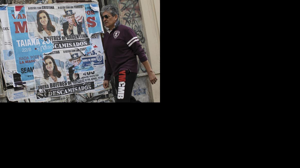 
Un hombre pasa junto a un cartel con un mensaje en contra de los llamados fondos ‘buitre’ el martes en el centro de Buenos Aires. Argentina depositó $161 millones el pago de sus acreedores de deuda reestructurada, informó el Ministerio de Economía. 
