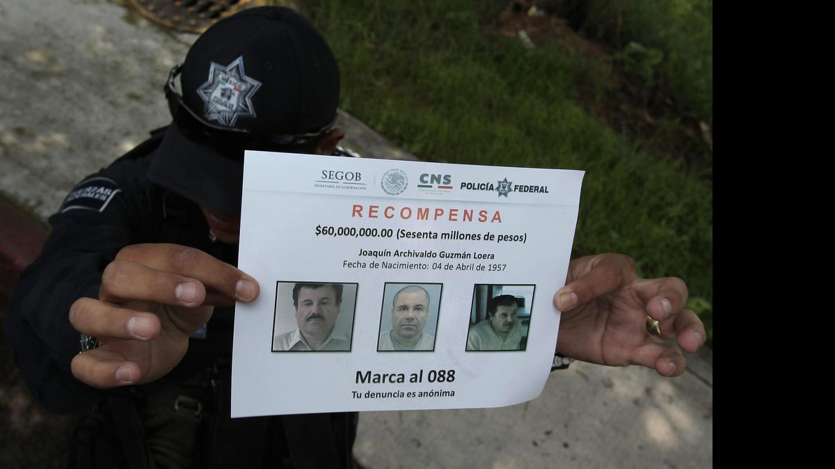 
Un policía muestra un aviso de recompensa, mientras se adelantan investigaciones en la casa donde se construyó el túnel por el que escapó el narcotraficante Joaquín ‘El Chapo’ Guzmán de su celda de la cárcel Altiplano I, en el municipio de Almoloya del céntrico Estado de México.
