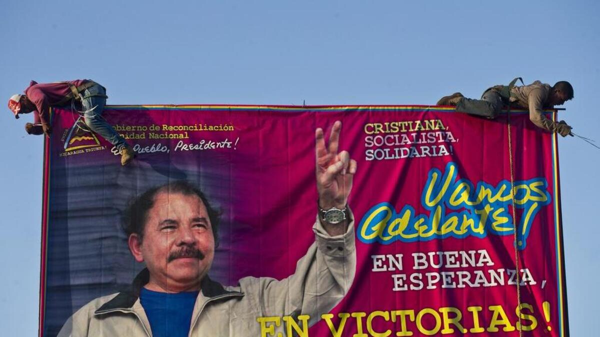 Obreros colocan un cartel de propaganda política a favor de Daniel Ortega en Managua en diciembre pasado.