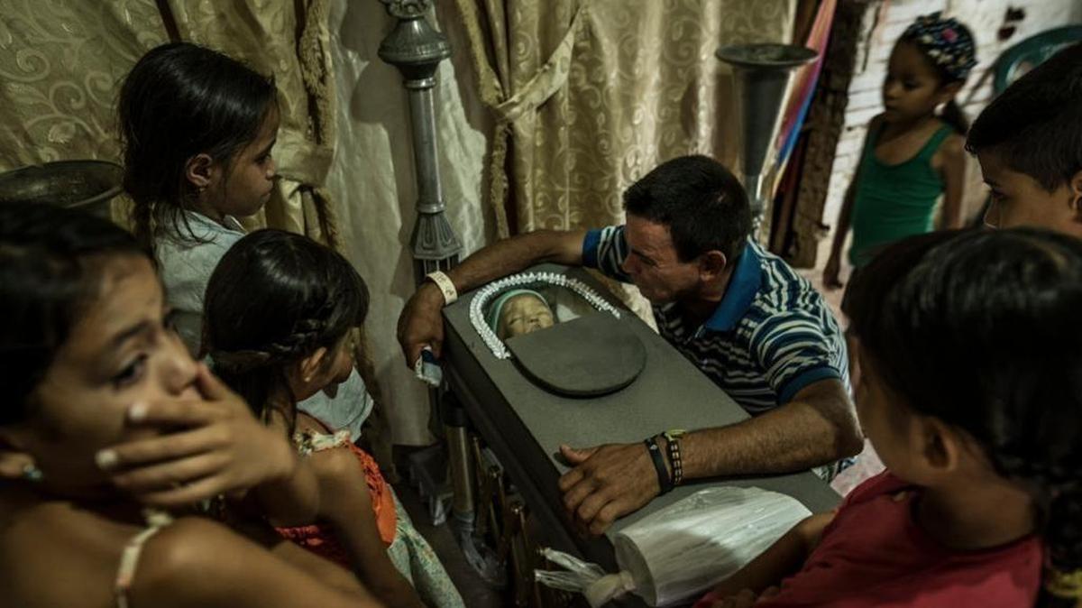 Carlos Aquino llora sobre el cuerpo de su hijo de 17 meses, que murió debido a una severa desnutrición en San Casimiro, Venezuela, en agosto del 2017.