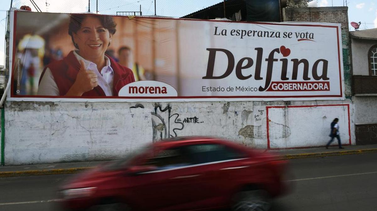 Un coche pasa por una pared pintada con publicidad de campaña para Delfina Gómez, candidata del Movimiento de Regeneración Nacional (MORENA) para la gobernación del estado de México, en Texcoco el 2 de junio de 2017.