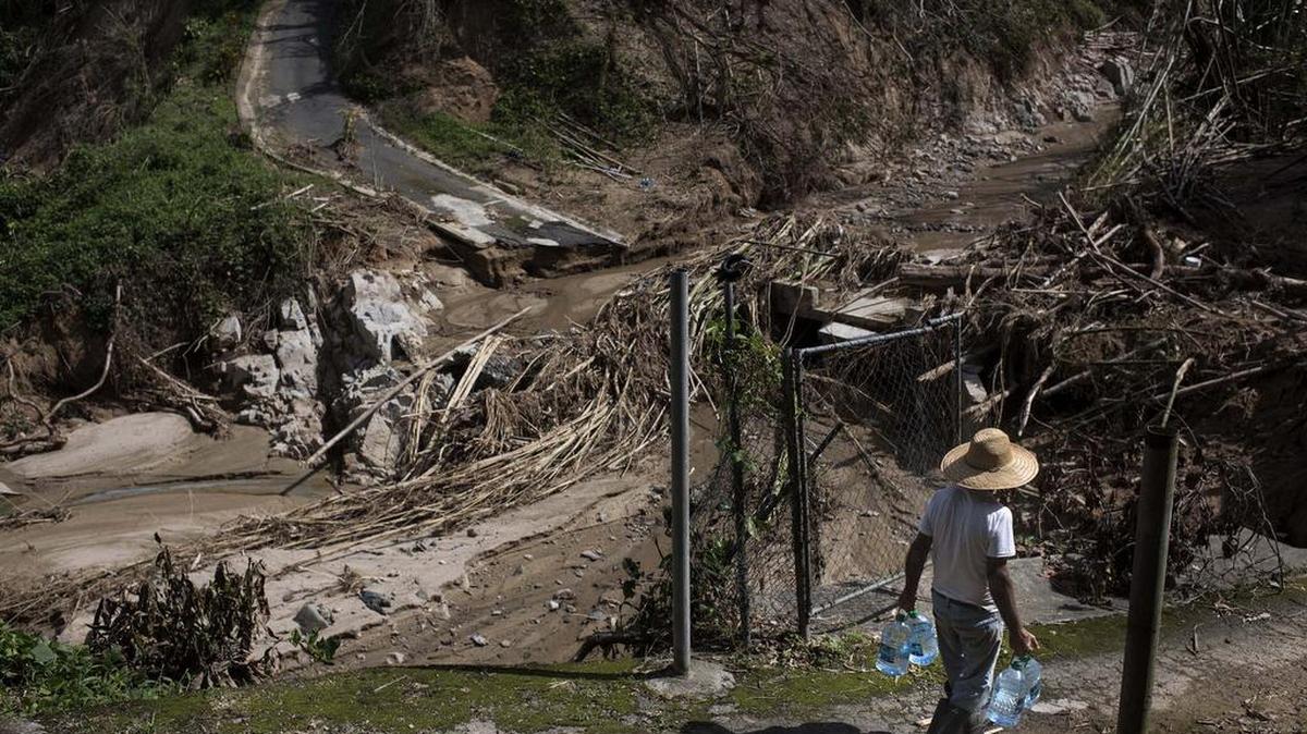 Un hombre carga agua embotellada en Utuado, Puerto Rico.