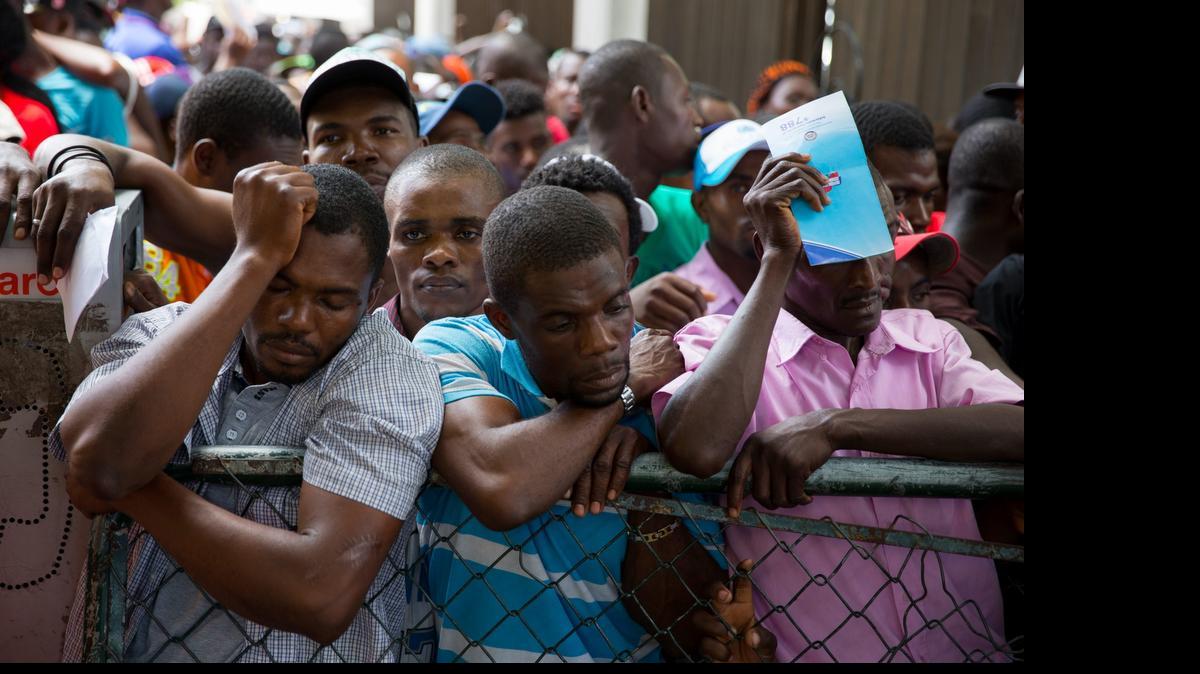 
Inmigrantes de origen haitiano esperan para poder realizar sus trámites en la sede del Ministerio de Interior y Policía el miércoles, en Santo Domingo.
