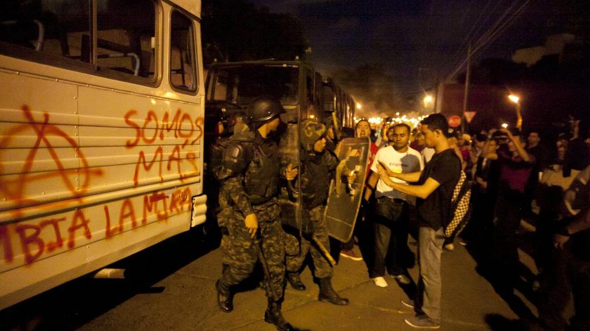
Militares buscan controlar a manifestantes el viernes 14 de agosto, durante una protesta, parte de la ‘marcha de las antorchas’, en Tegucigalpa. Un soldado de la Guardia de Honor Presidencial de Honduras (GHP) resultó lesionado en el rostro a causa de una pedrada cuando manifestantes del movimiento ‘Oposición Indignada’ intentaban llegar a la casa del presidente Juan Orlando Hernández. 
