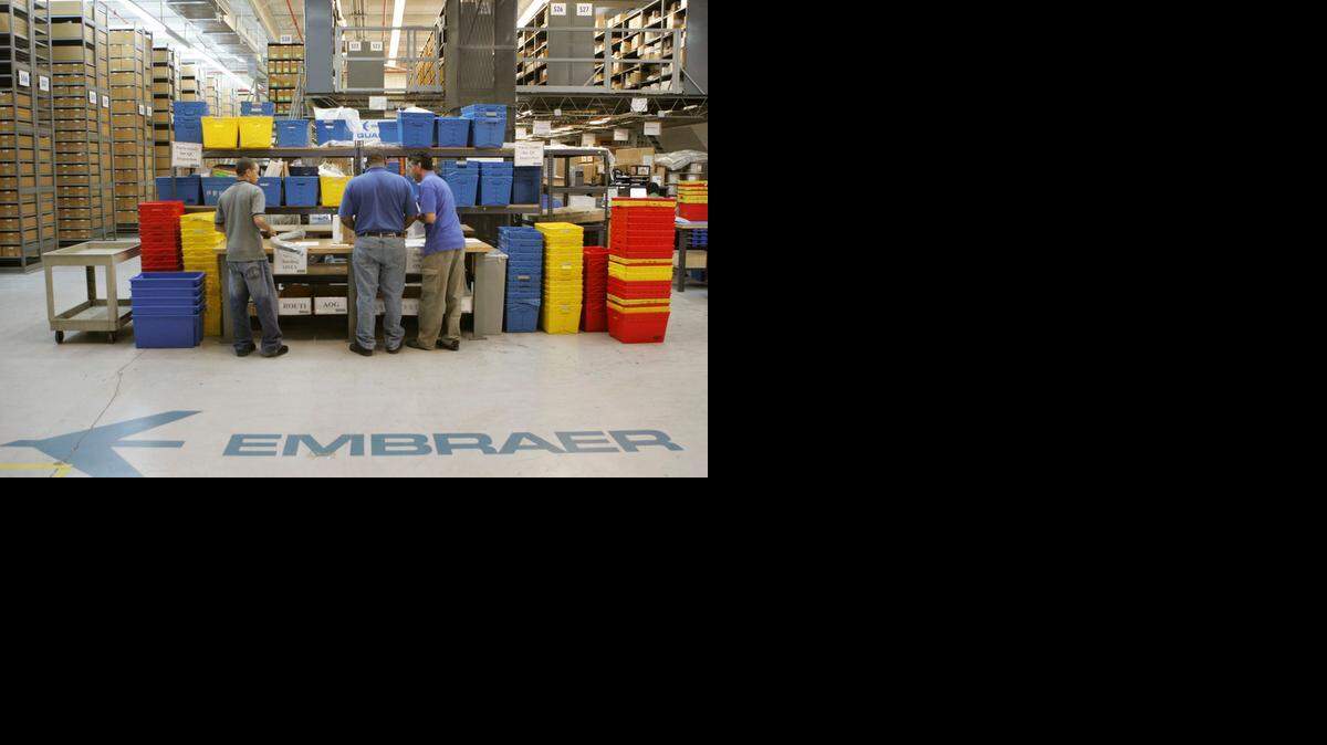 
Trabajadores en un almacén de Embraer en Fort Lauderdale clasifican partes de aviones. Foto archivo.
