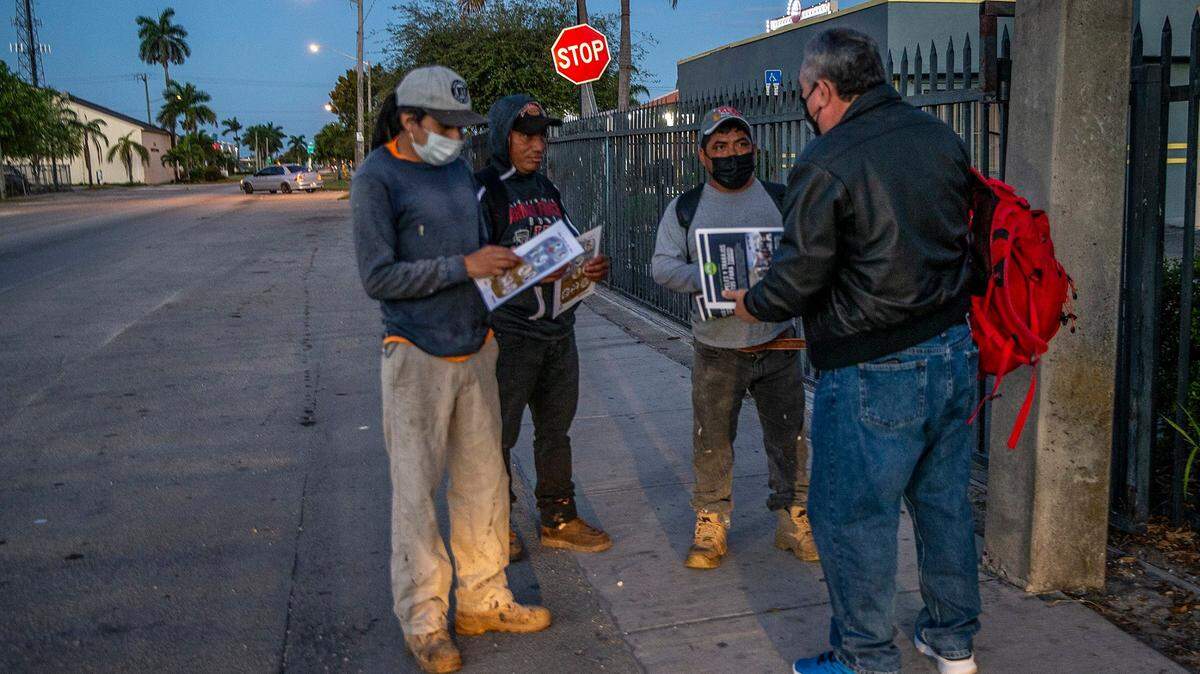 Erick Sánchez (centro), un organizador de los derechos de los trabajadores con WeCount!, distribuye volantes con información sobre los derechos de los trabajadores a los jornaleros en Homestead, en el sur de la Florida, la madrugada del miércoles 10 de marzo de 2021.