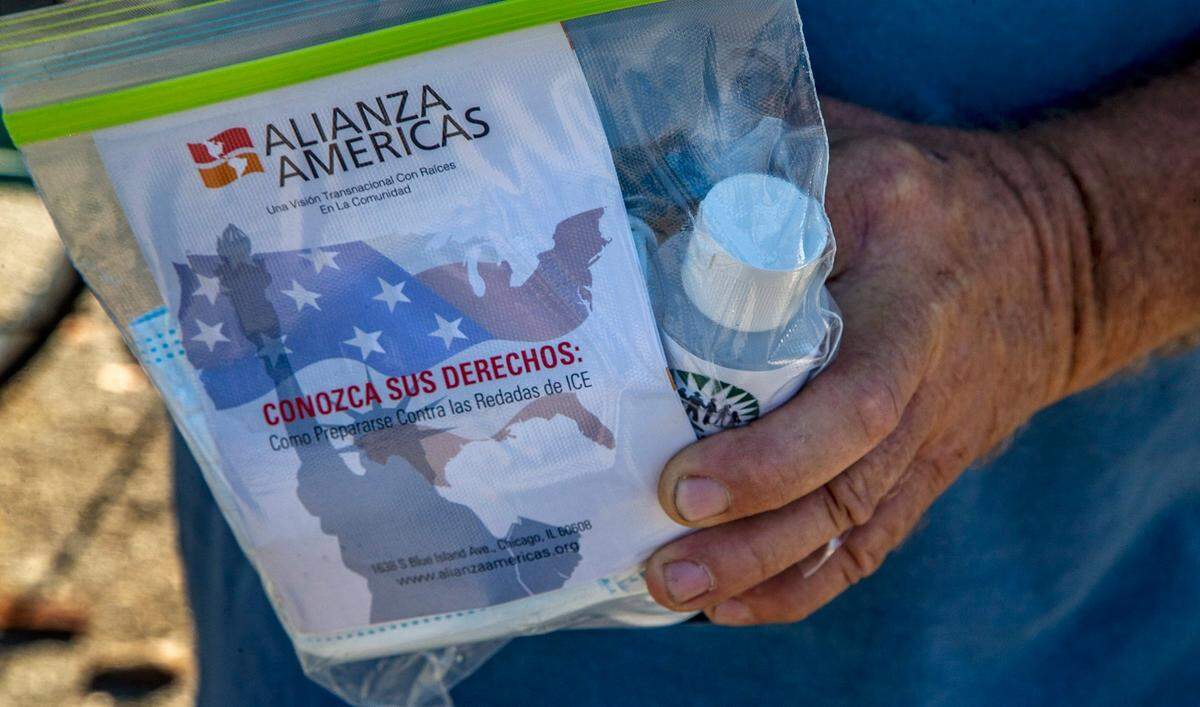 Un jornalero sostiene un kit de protección contra el COVID-19 que recibió de parte de Erick Sánchez, un empleado de WeCount!, en Homestead, en el sur de la Florida, el martes 3 de marzo de 2021.