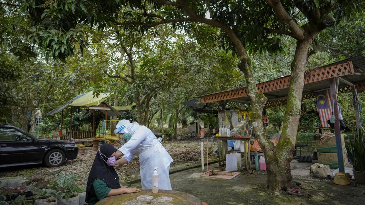 ARCHIVO - Una enfermera malasia pone la vacuna de Sinovac contra el COVID-19 a una anciana en su casa de Sabab Bernam, en el estado central de Selangor, Malasia, el 13 de julio de 2021. (AP Foto/Vincent Thian, Archivo)
