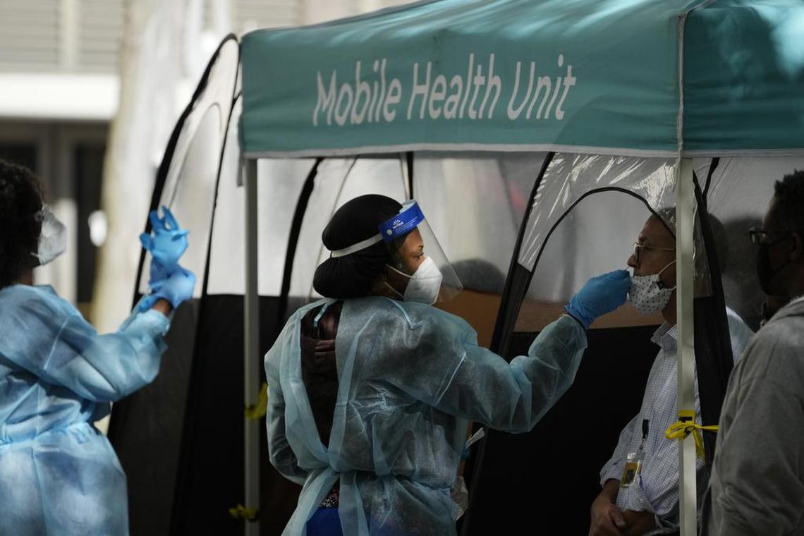 A man is tested for COVID-19 at a walk-up testing site run by Nomi Health in downtown Miami on Dec. 28, 2021.
