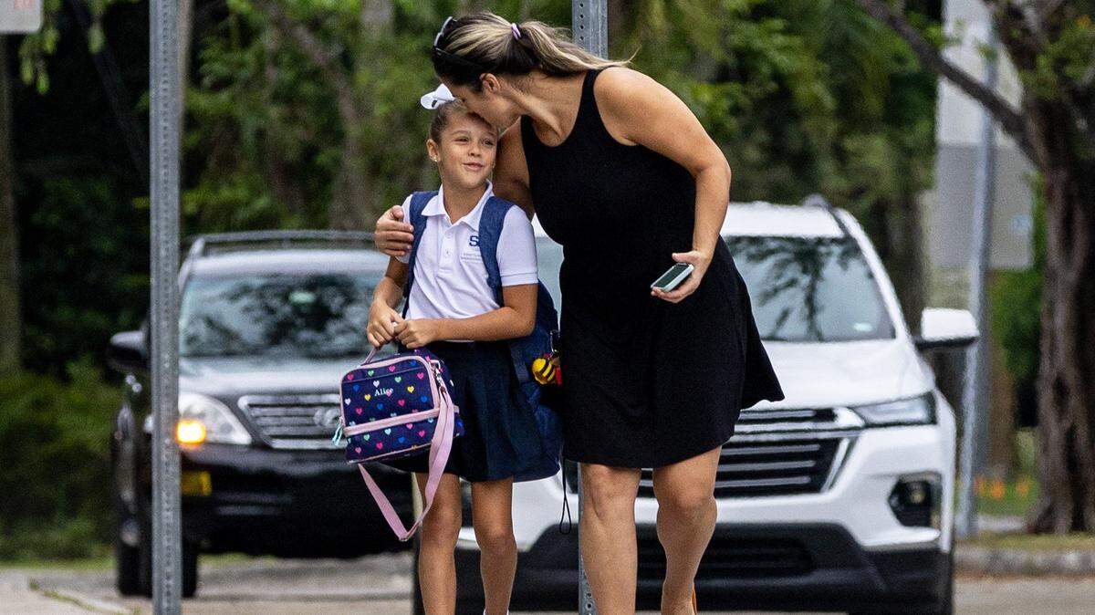 Alice Fatjo abraza y besa a su hija Yodi Martínez antes de dejarla en la escuela en el primer día de clases en Sunset Elementary en South Miami, Florida, el jueves 17 de agosto de 2023.