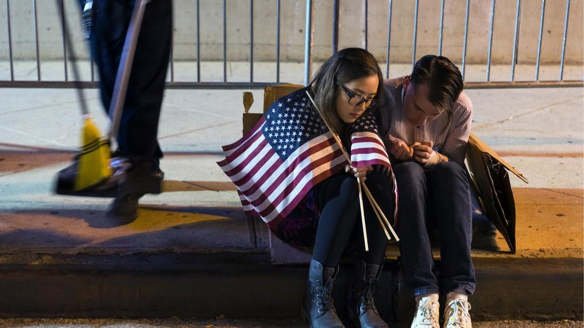 La gente se sienta fuera del centro Jacob Javits, esperando los resultados de las elecciones luego de un mitin por la candidata demócrata a la presidencia Hillary Clinton en Nueva York Miércoles 9 de noviembre de 2016.