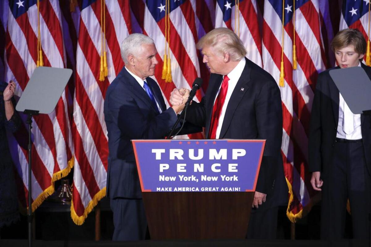El candidato republicano a la Presidencia, Donald Trump (dcha), estrecha la mano a su número 2 Mike Pence mientras se presenta ante sus simpatizantes durante la fiesta electoral organizada en el New York Hilton Midtown de Nueva York (Estados Unidos) en la noche del 8 de noviembre de 2016.
