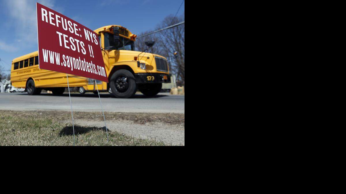 
Un bus escolar pasa frente a un letrero que invita a rechazar los exámanes estandarizados, en Rotterdam, NY. 

