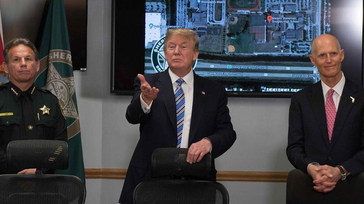 El presidente de EEUU, Donald Trump habla con jefe de policía del condado Broward Scott Israel y el gobernador de Florida Rick Scott durante la visita condado de Broward en Pompano Beach, Florida, el 16 de febrero de 2018, tres días después tiroteo masivo que cobró 17 vidas en una escuela secundaria cercana.