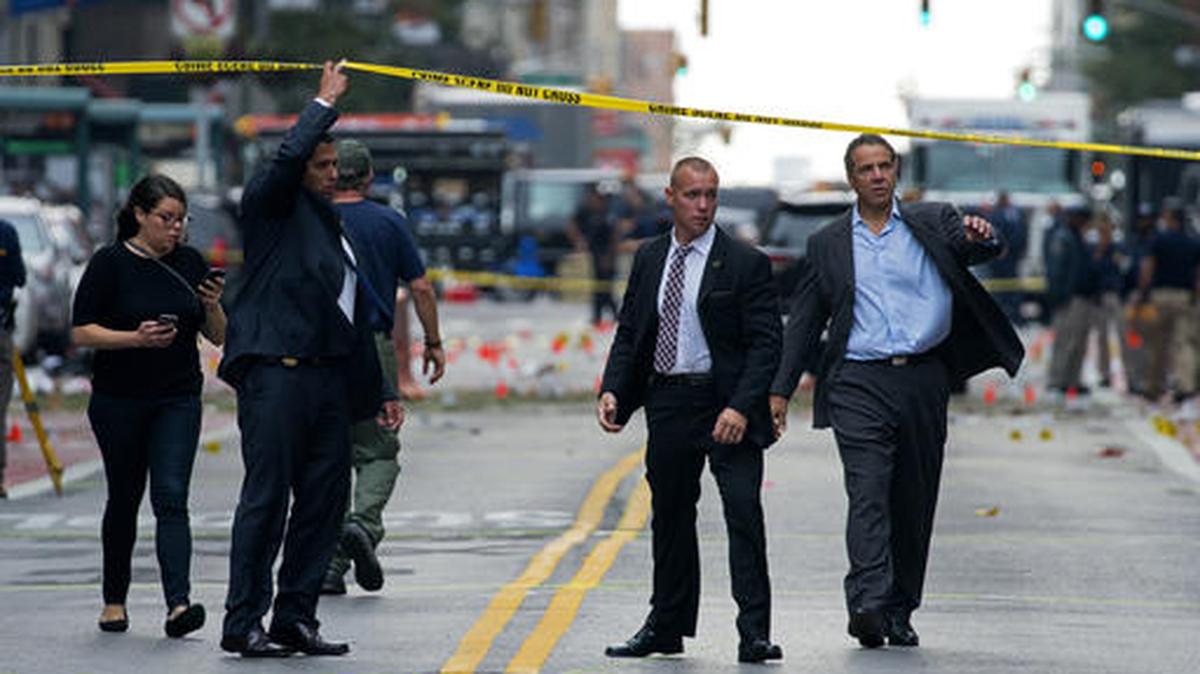 El gobernador de Nueva York Andrew Cuomo, derecha, camina desde la escena de la explosión en el barrio de Chelsea, en Manhattan, el domingo 18 de septiembre. 