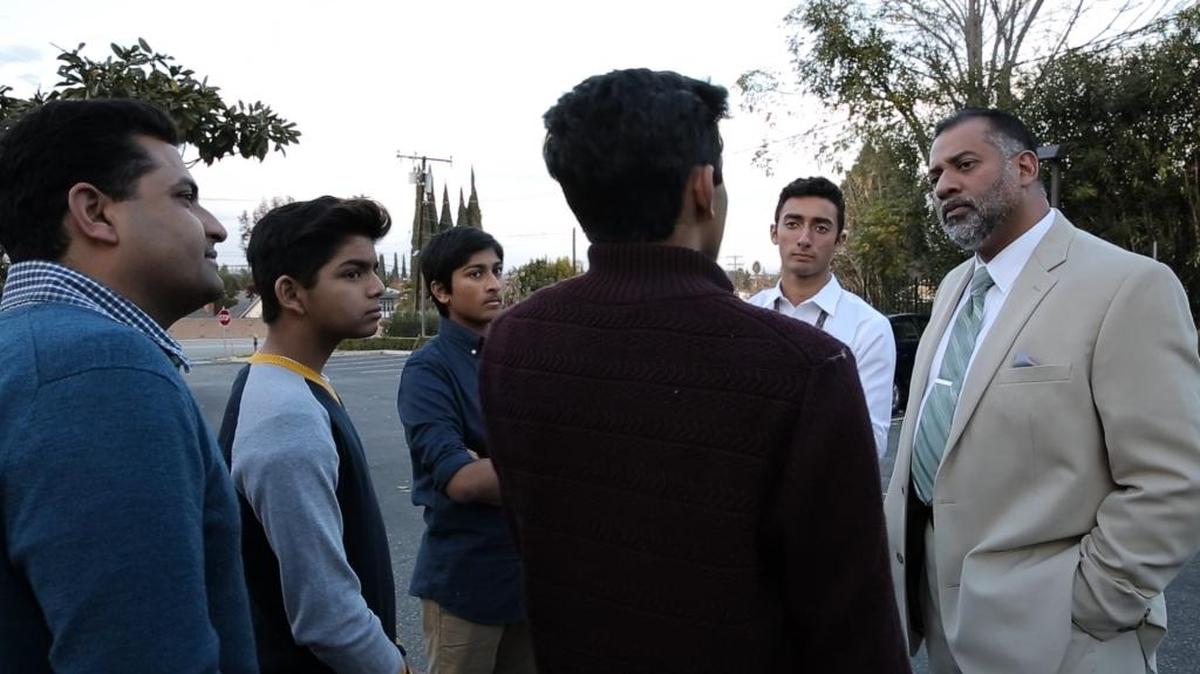 El doctor Rushdi Abdul Cader (der.) conversa con un grupo de adolescentes luego de una charla de AntiVIRUS en el Centro Islámico de Conejo Valley en San Luis Obispo, California