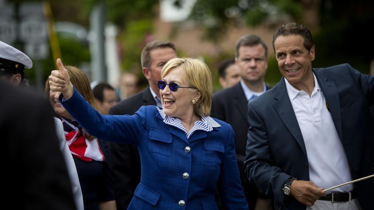 La candidata demócrata Hillary Clinton camina junto al gobernador de Nueva York Andrew M. Cuomo en el desfile del Memorial Day.