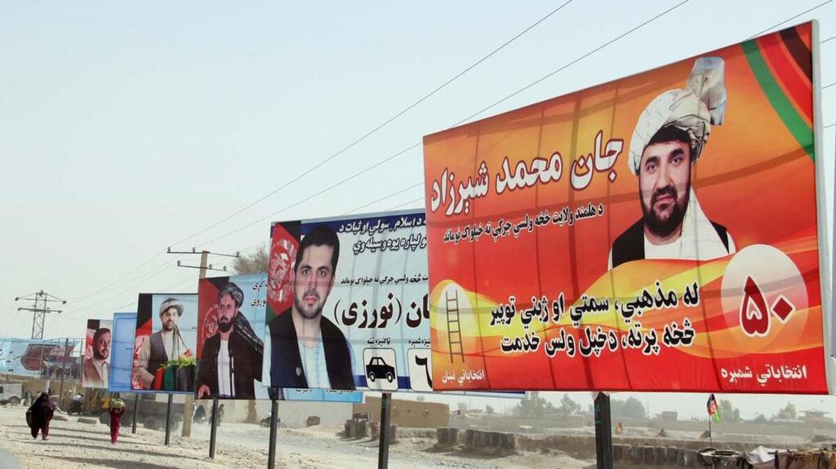 Varios carteles electorales situados junto a una carretera en Helmand, Afganistán.