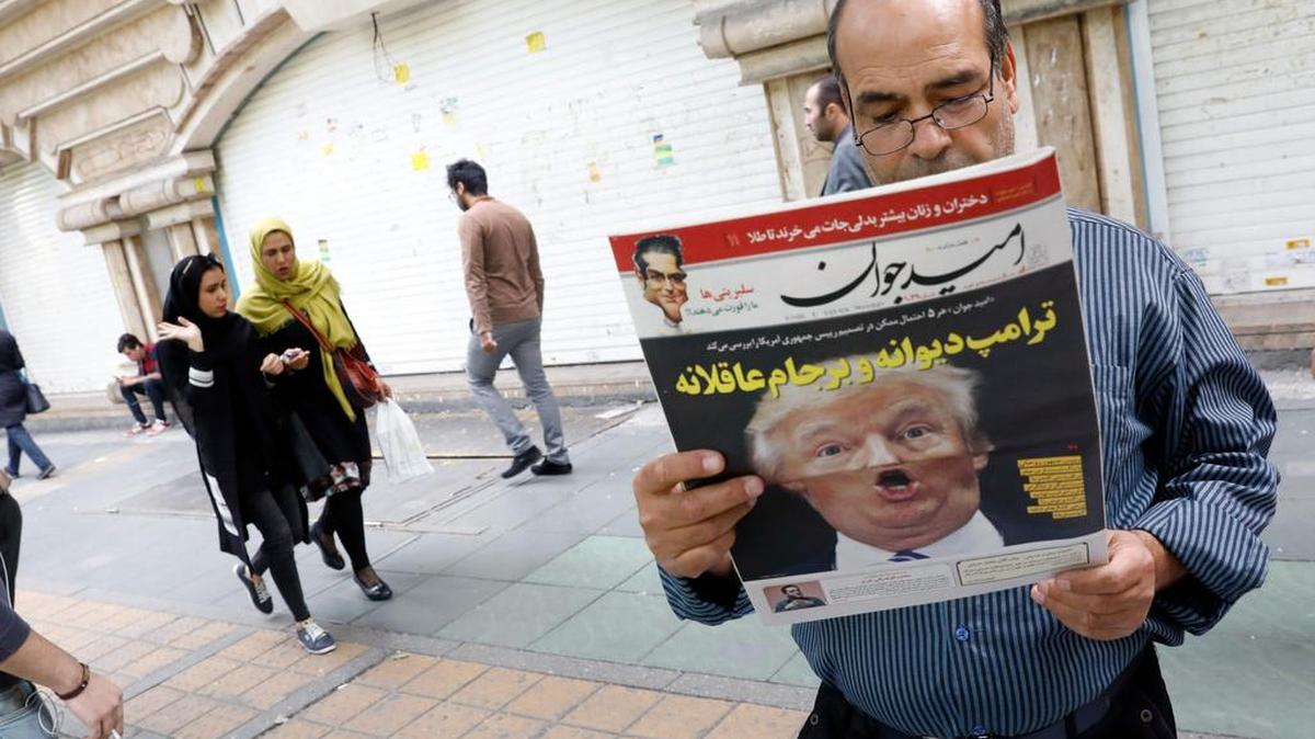 Un iraní lee una copia del diario 'Omid Javan' con una imagen del presidente de los Estados Unidos, Donald Trump, el 14 de octubre de 2017, frente a un quiosco en la capital Teherán.