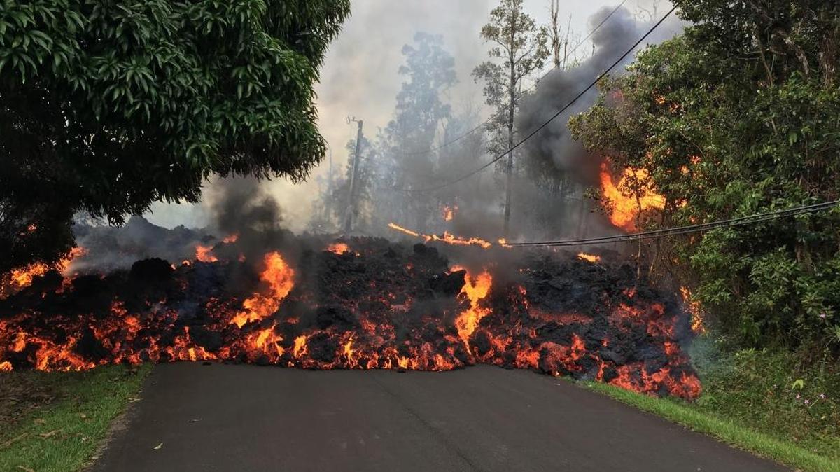Imagen proporcionada por el Servicio Geológico de Estados Unidos, que muestra la lava recorriendo por Makamae Street, en Leilani Estates, Hawái, el 6 de mayo de 2018.