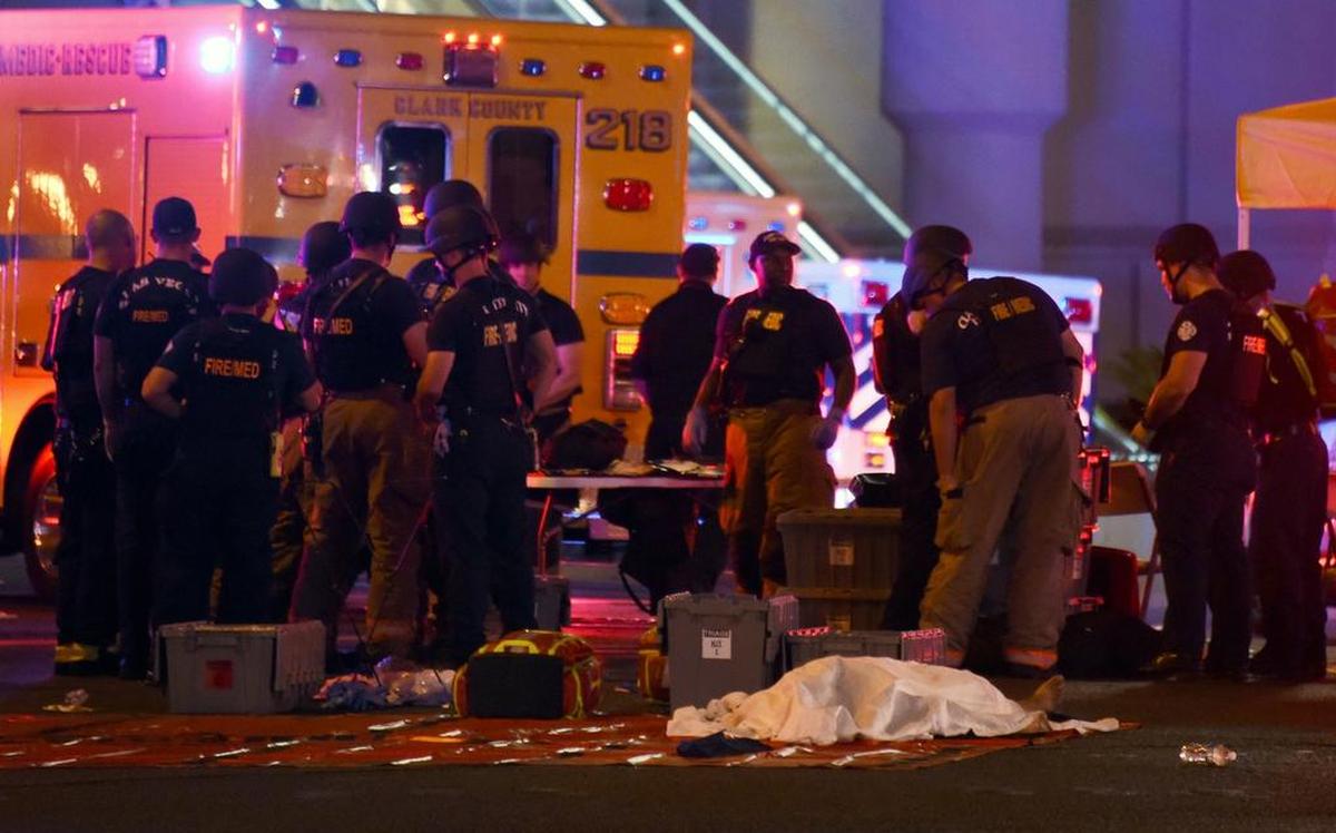 Un cuerpo yace debajo de una sábana mientras la policía y el personal de rescate se reúnen en la intersección de Las Vegas Boulevard y la avenida Tropicana después de un tiroteo en un festival de música country el 2 de octubre de 2017 en Las Vegas, Nevada.
